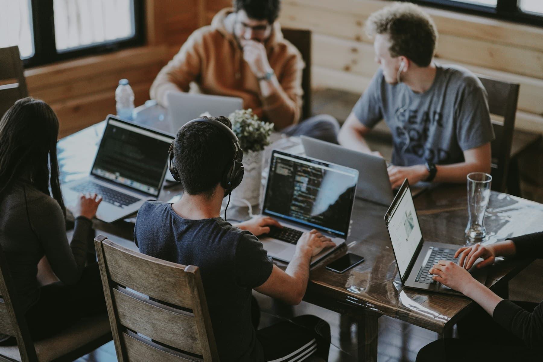 A team collaborating around a wooden table in a bright office